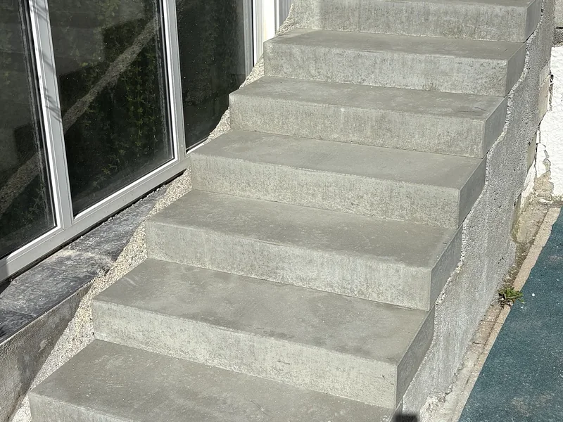Neue Gartentreppe aus Betonblockstufen neben einer Terrassentür