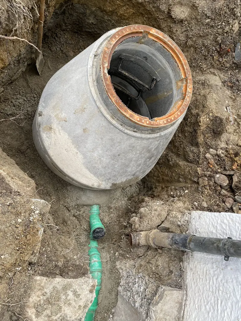 Neuer Betonschacht in der Baugrube mit angeschlossenem Abwasserrohr