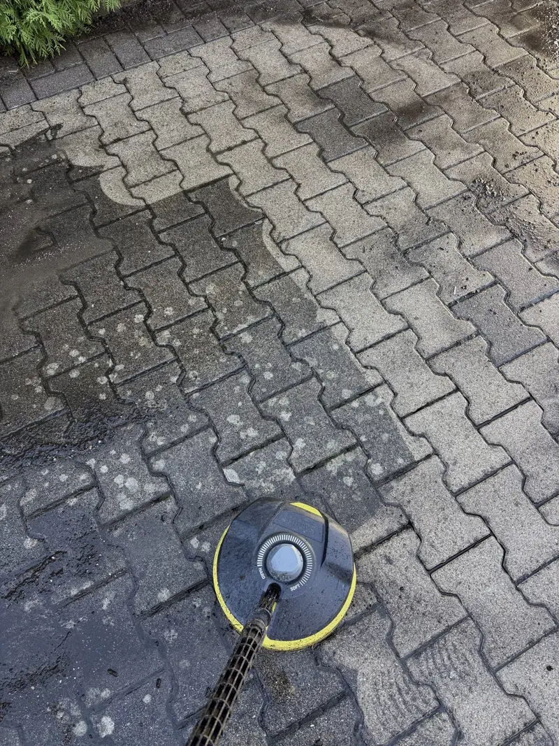 Pflasterfläche bei der Reinigung: gereinigter Streifen neben verschmutztem Pflaster