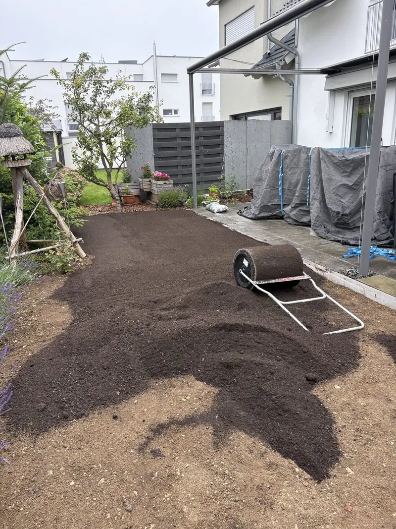Neuer Mutterboden wird mit der Walze eingeebnet